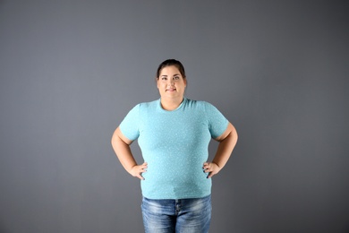 Portrait of overweight woman on gray background