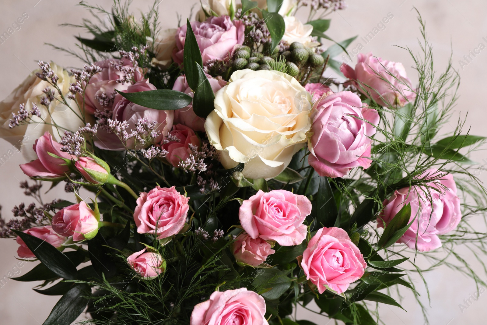 Photo of Beautiful bouquet with roses on beige background, closeup