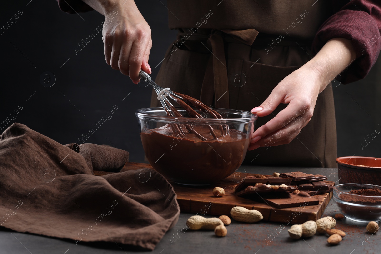 Photo of Woman with whisk mixing delicious chocolate cream at table, closeup