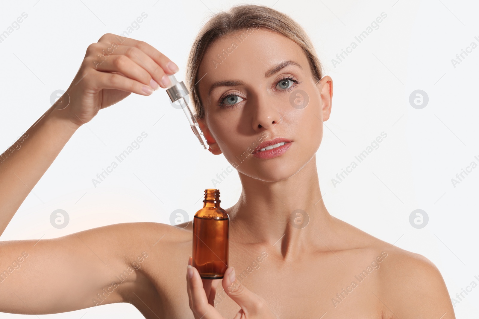 Photo of Beautiful woman with cosmetic serum in her hands on white background