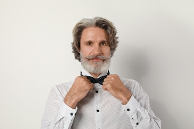 Portrait of handsome mature man on light background