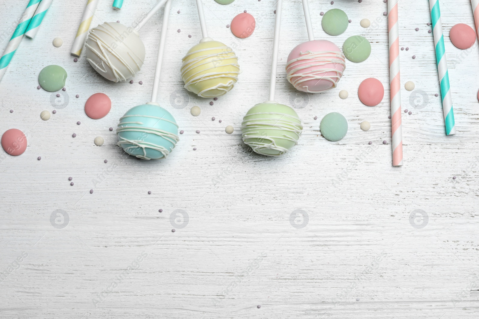 Photo of Flat lay composition with sweet cake pops on white wooden background. Space for text