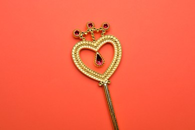 Photo of Beautiful golden magic wand on coral background, top view