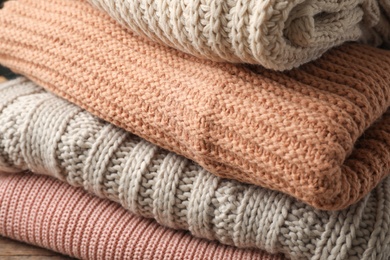 Stack of folded warm knitted sweaters, closeup