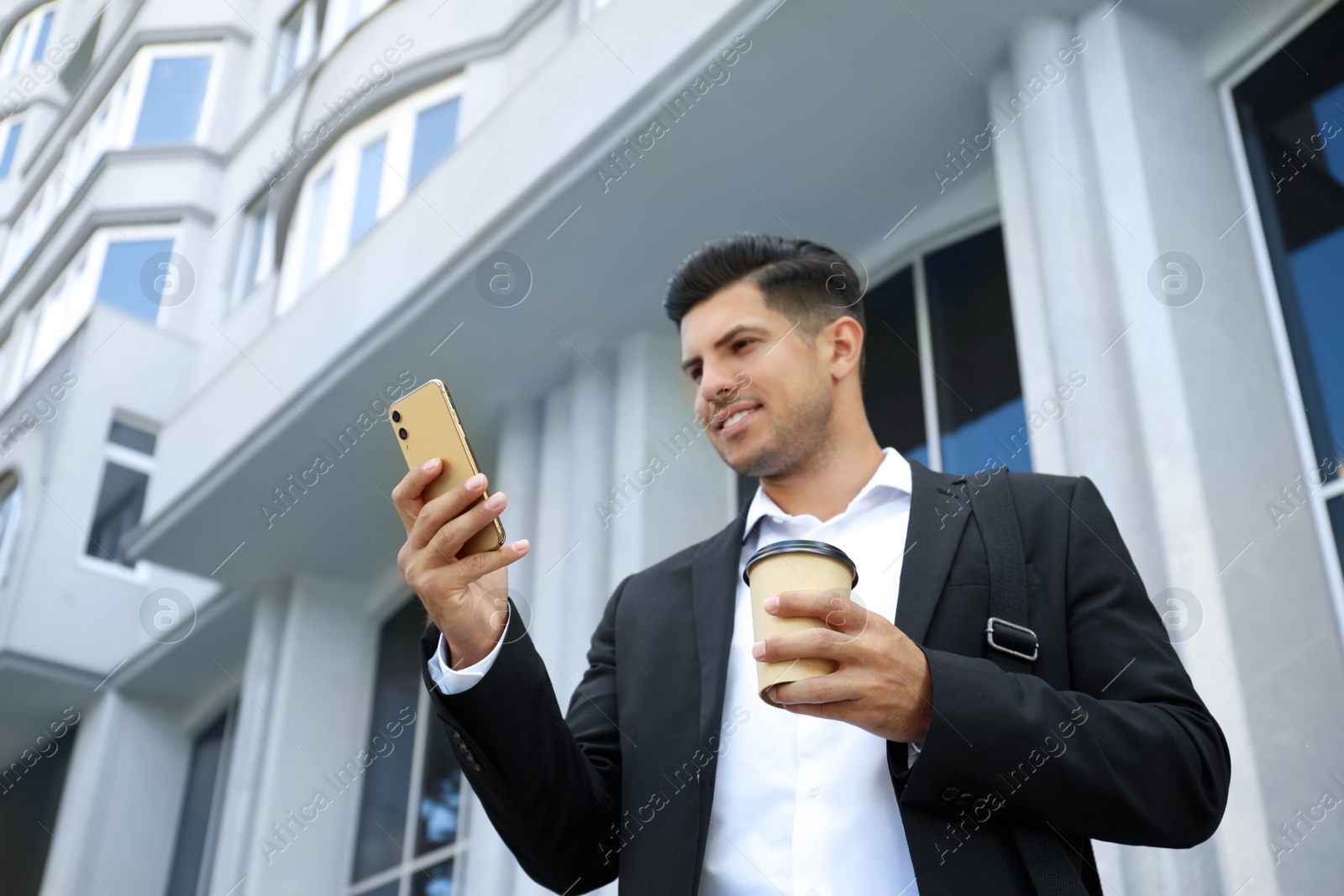 Photo of Handsome man with smartphone on city street