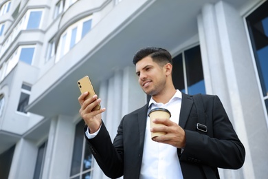 Photo of Handsome man with smartphone on city street