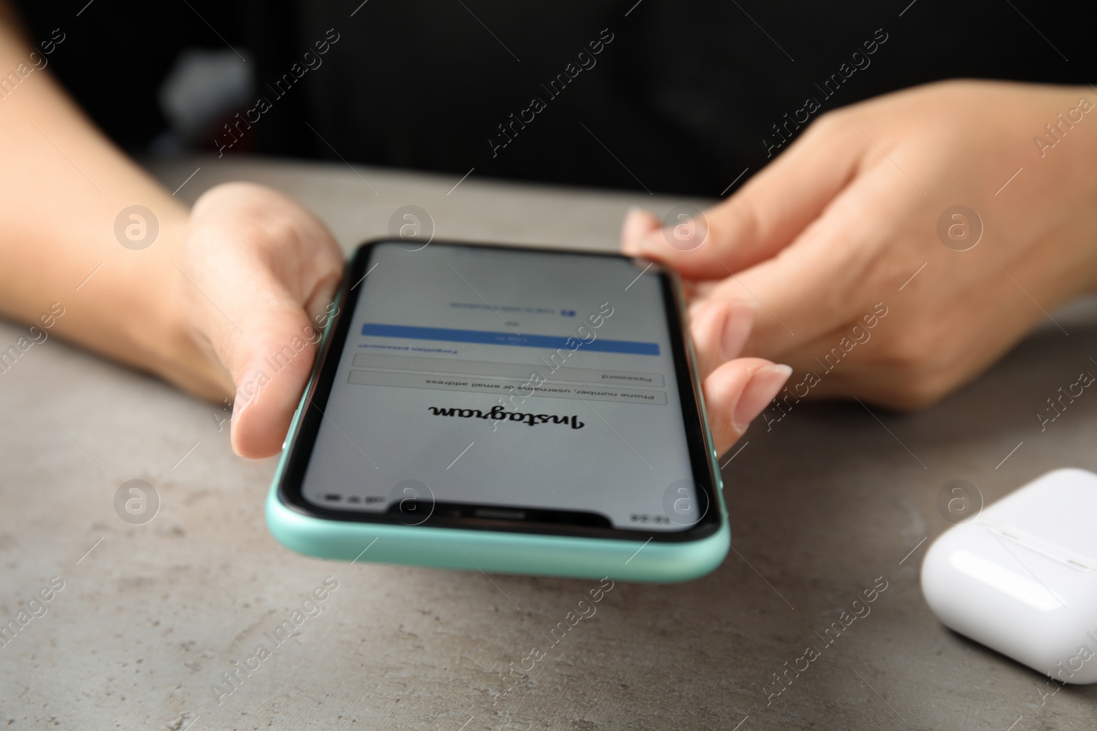 Photo of MYKOLAIV, UKRAINE - JULY 9, 2020: Woman using Instagram app on Iphone 11 at table, closeup