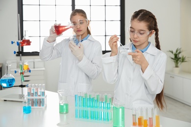 Photo of Smart pupils making experiment in chemistry class