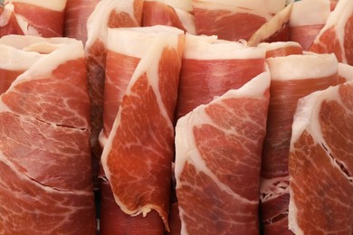 Photo of Rolled slices of delicious jamon as background, closeup