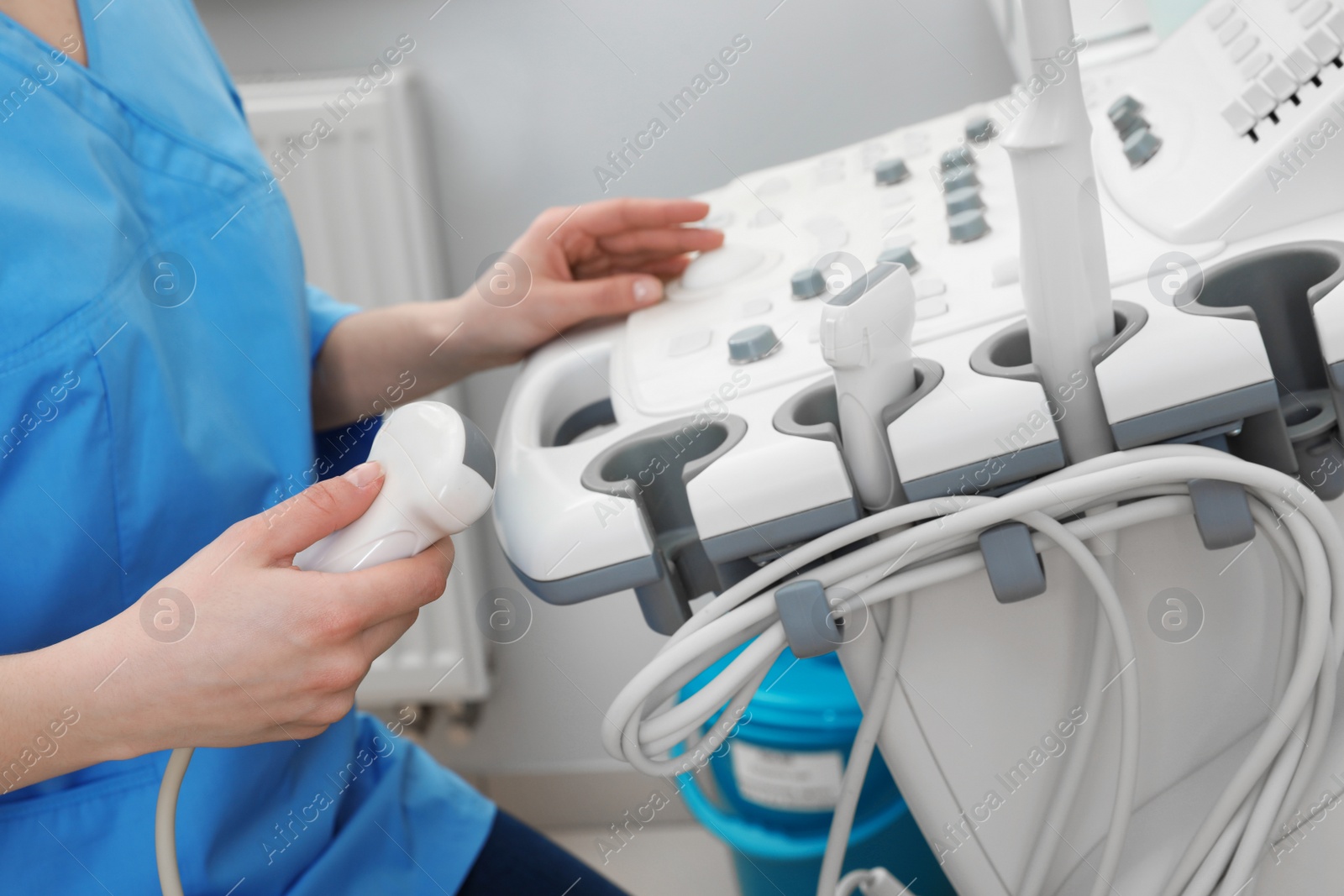 Photo of Sonographer operating modern ultrasound machine in clinic, closeup