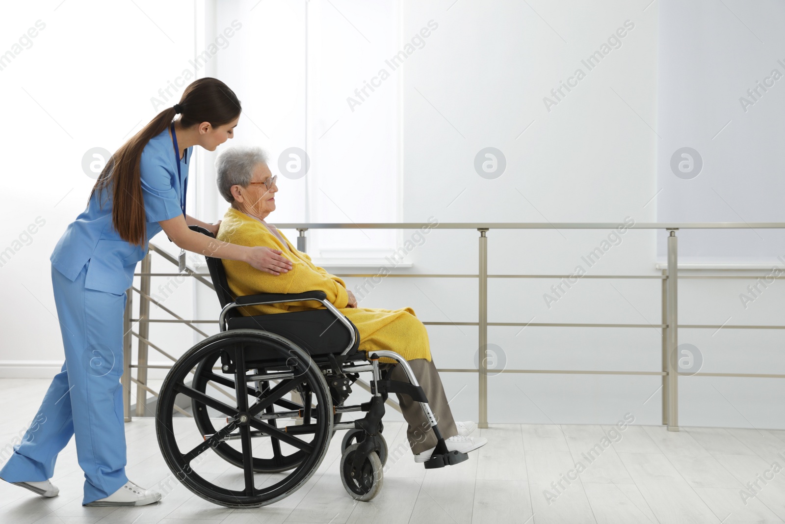 Photo of Nurse assisting senior woman in wheelchair at hospital