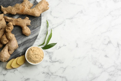 Photo of Dry ginger powder, fresh root and leaves on white marble table, flat lay. Space for text