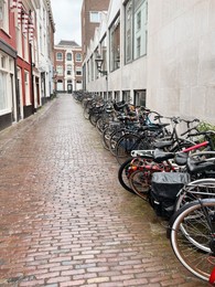 Photo of Many parked bicycles near building on city street