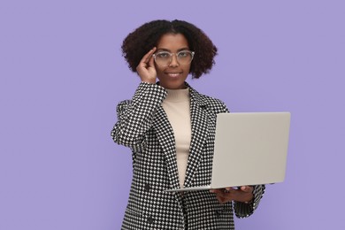 African American intern working on laptop against purple background