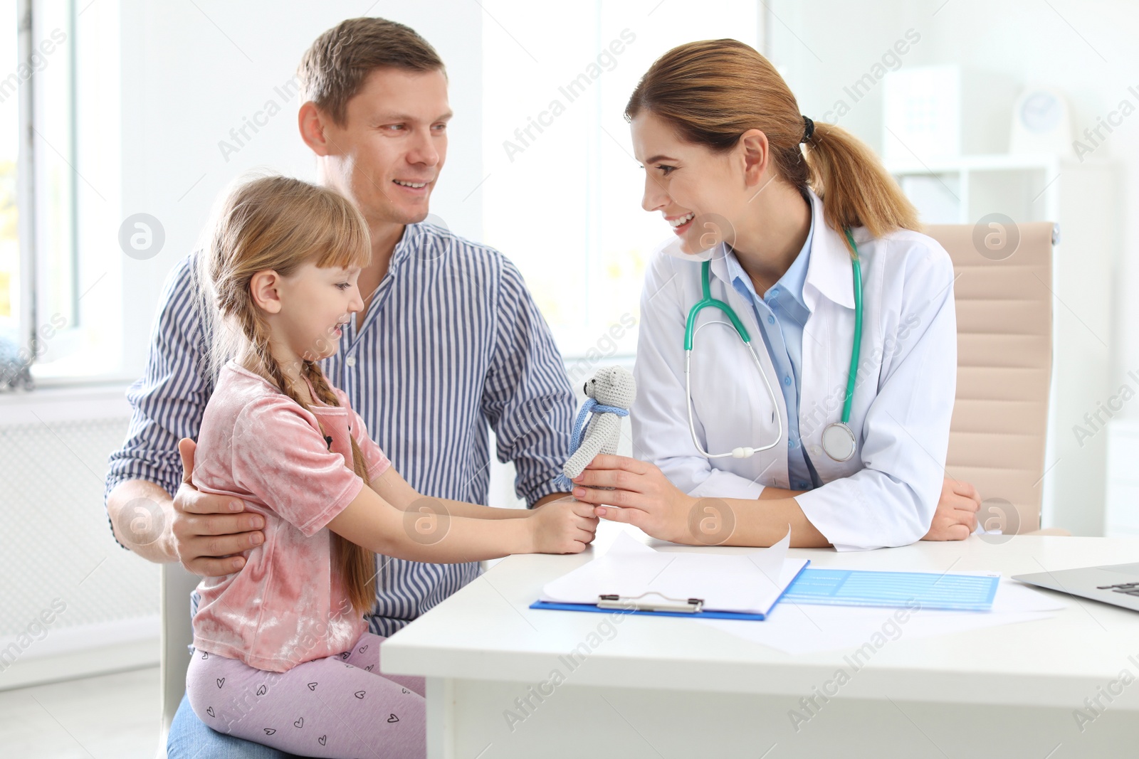 Photo of Little girl with parent visiting children's doctor in hospital