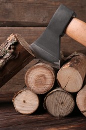 Photo of Metal ax and wooden logs on table
