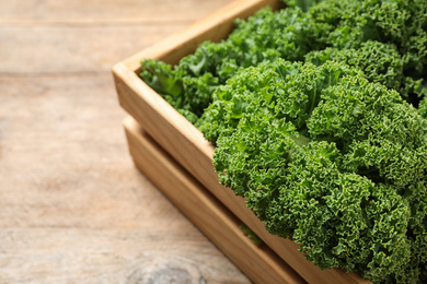 Fresh kale leaves on wooden table, closeup