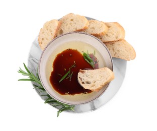 Photo of Bowl of balsamic vinegar with oil, rosemary and bread slices on white background, top view