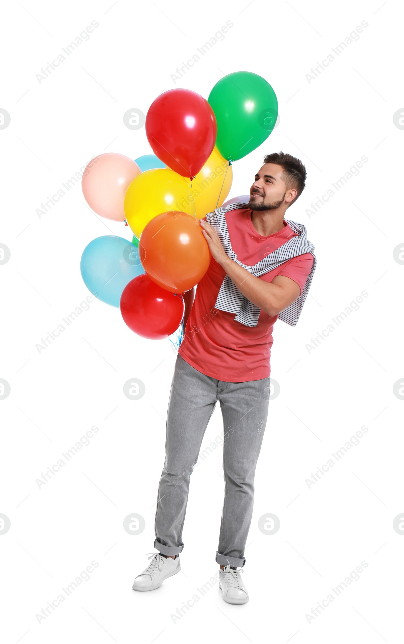 Photo of Young man holding bunch of colorful balloons on white background