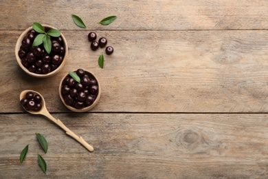 Photo of Flat lay composition with tasty acai berries on wooden table. Space for text