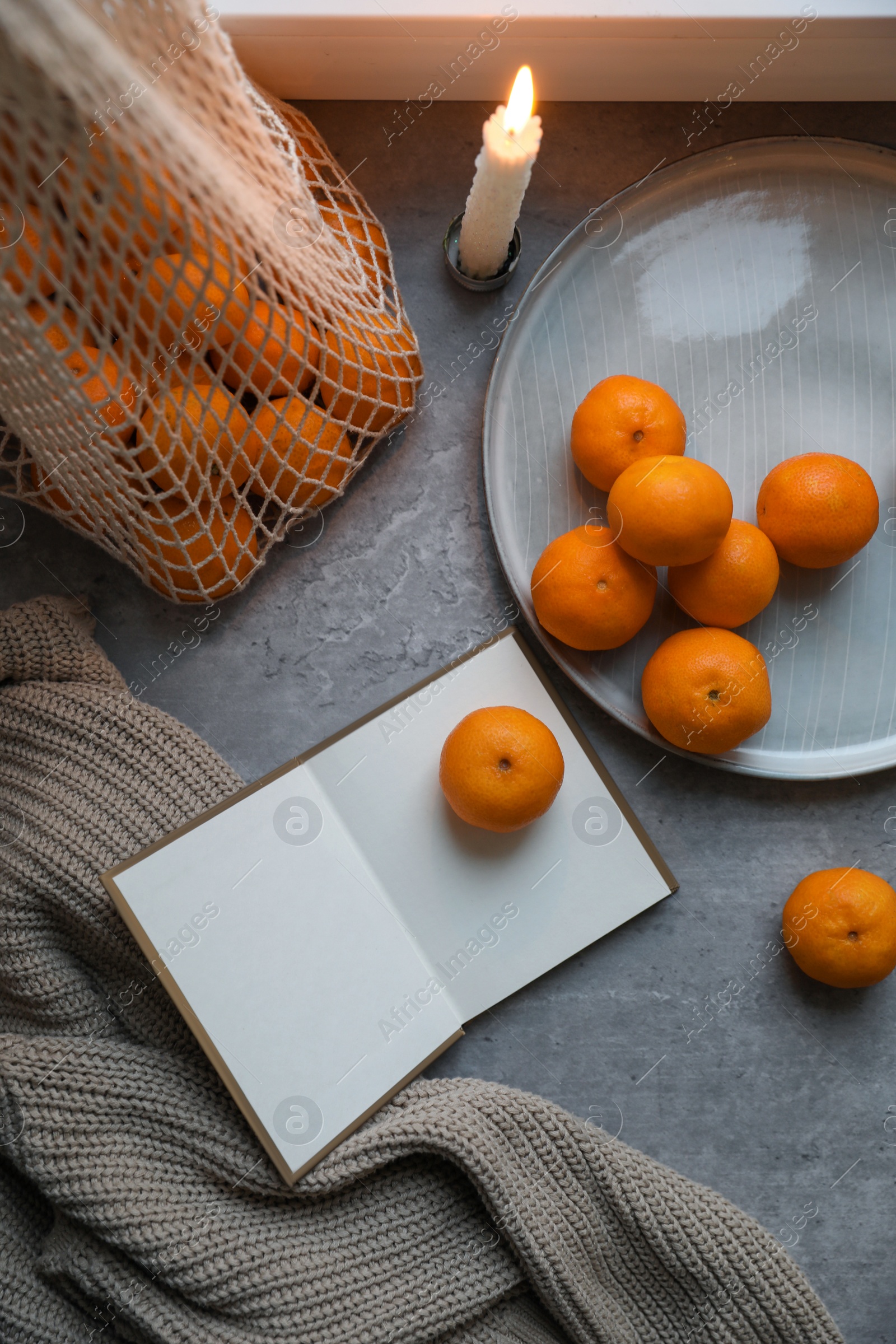 Photo of Flat lay composition with fresh ripe tangerines and book on light grey table