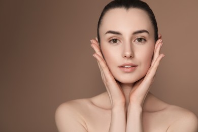 Portrait of beautiful young woman on brown background. Space for text