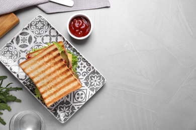 Photo of Tasty sandwich served on grey table, flat lay. Space for text