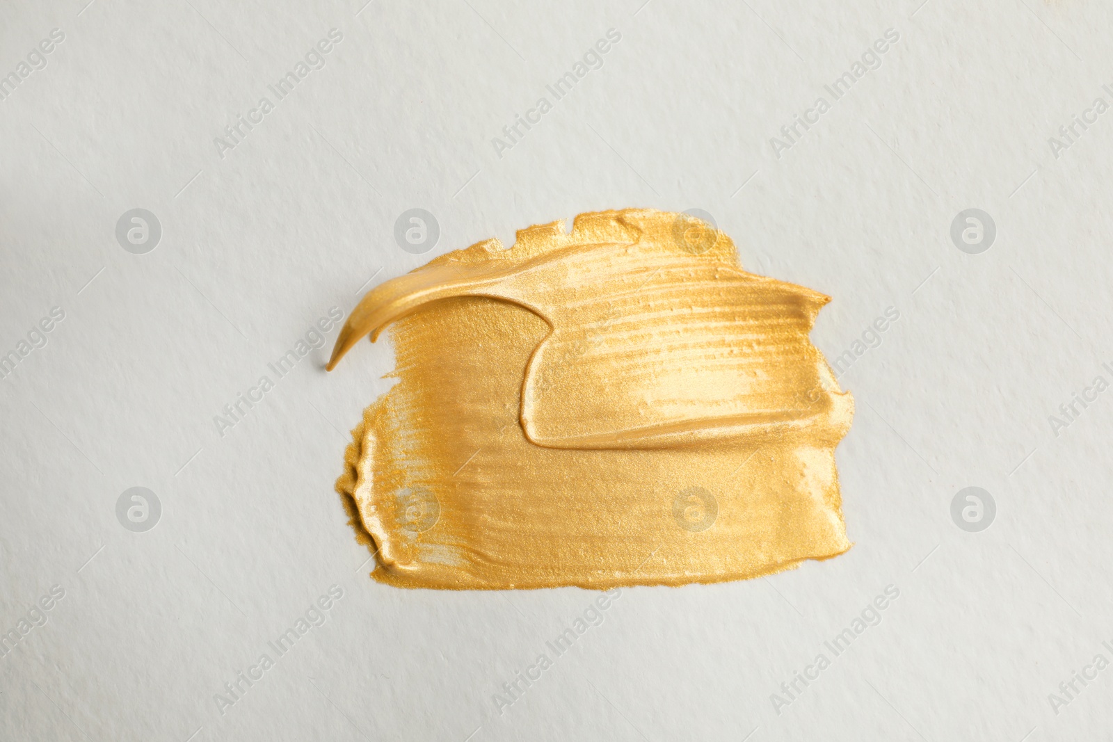 Photo of Golden paint brush strokes on white background