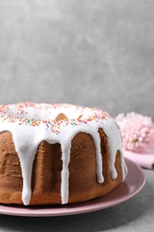 Glazed Easter cake with sprinkles on grey table, closeup