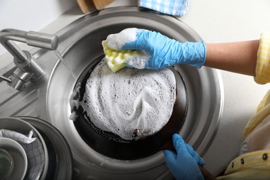 Photo of Woman washing dirty frying pan in sink, above view