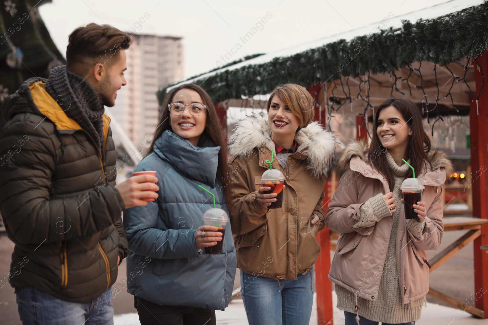 Photo of Friends with cups of mulled wine at winter fair