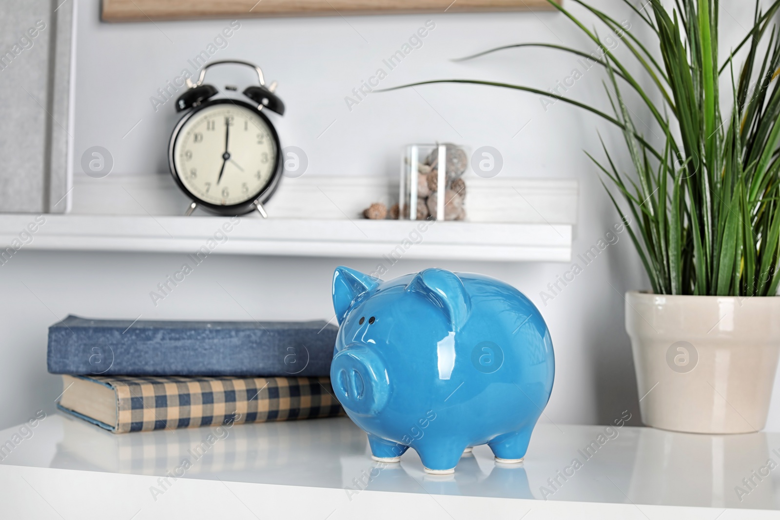 Photo of Cute piggy bank on table indoors. Stylish interior