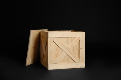 Photo of One open wooden crate on black background