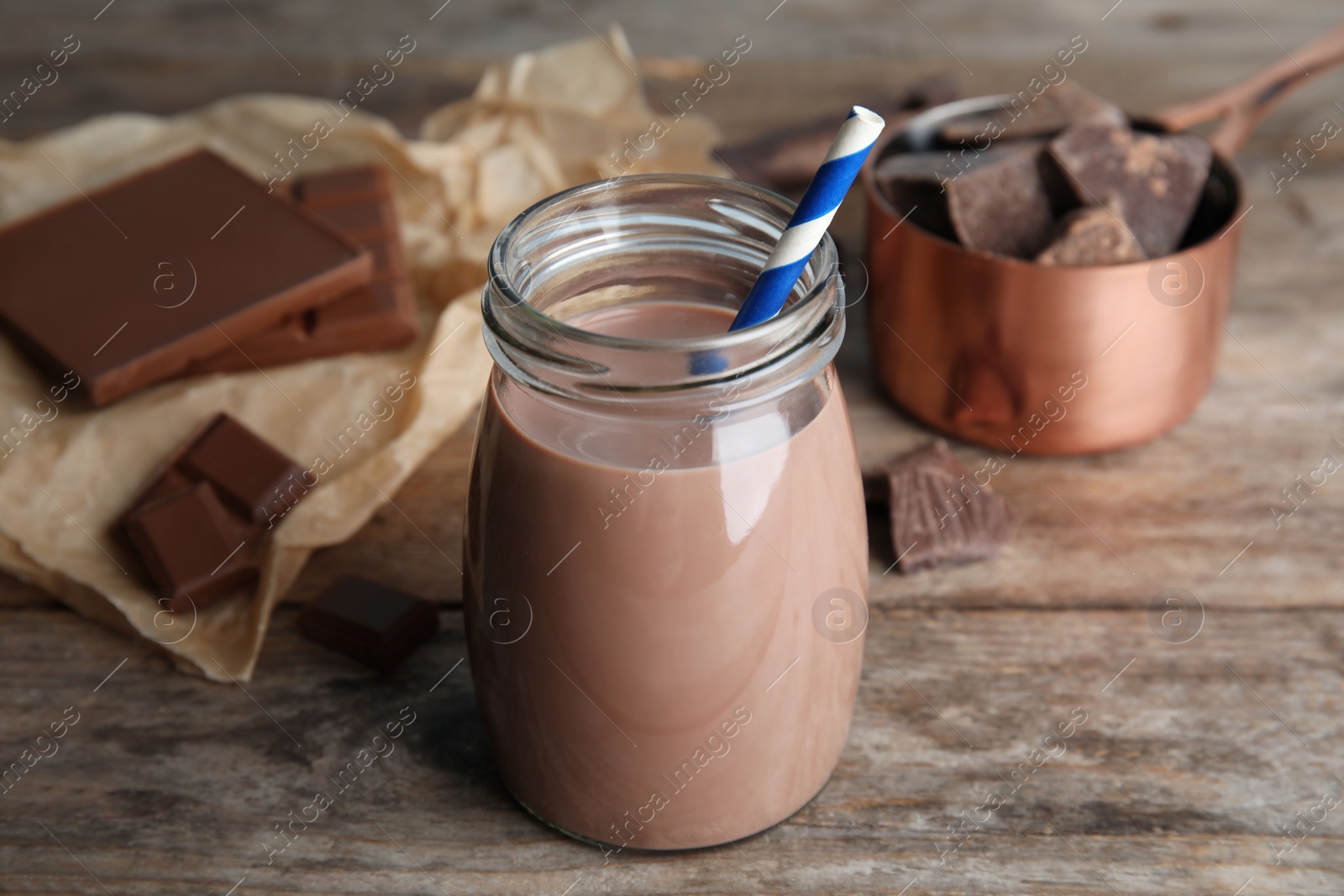 Photo of Jar with tasty chocolate milk on wooden table. Dairy drink