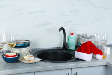 Photo of Dirty dishes near sink in kitchen after party