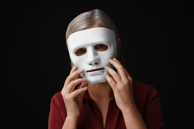 Photo of Multiple personality concept. Woman in mask on black background
