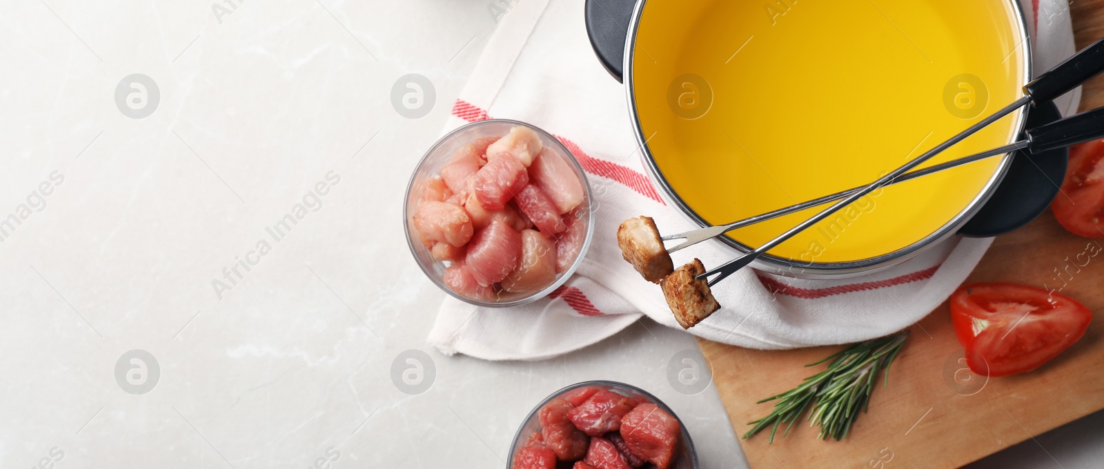 Image of Flat lay composition with fondue pot and meat on light table, space for text. Banner design