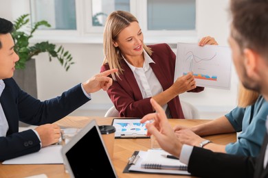 Photo of Businesswoman showing chart on meeting in office