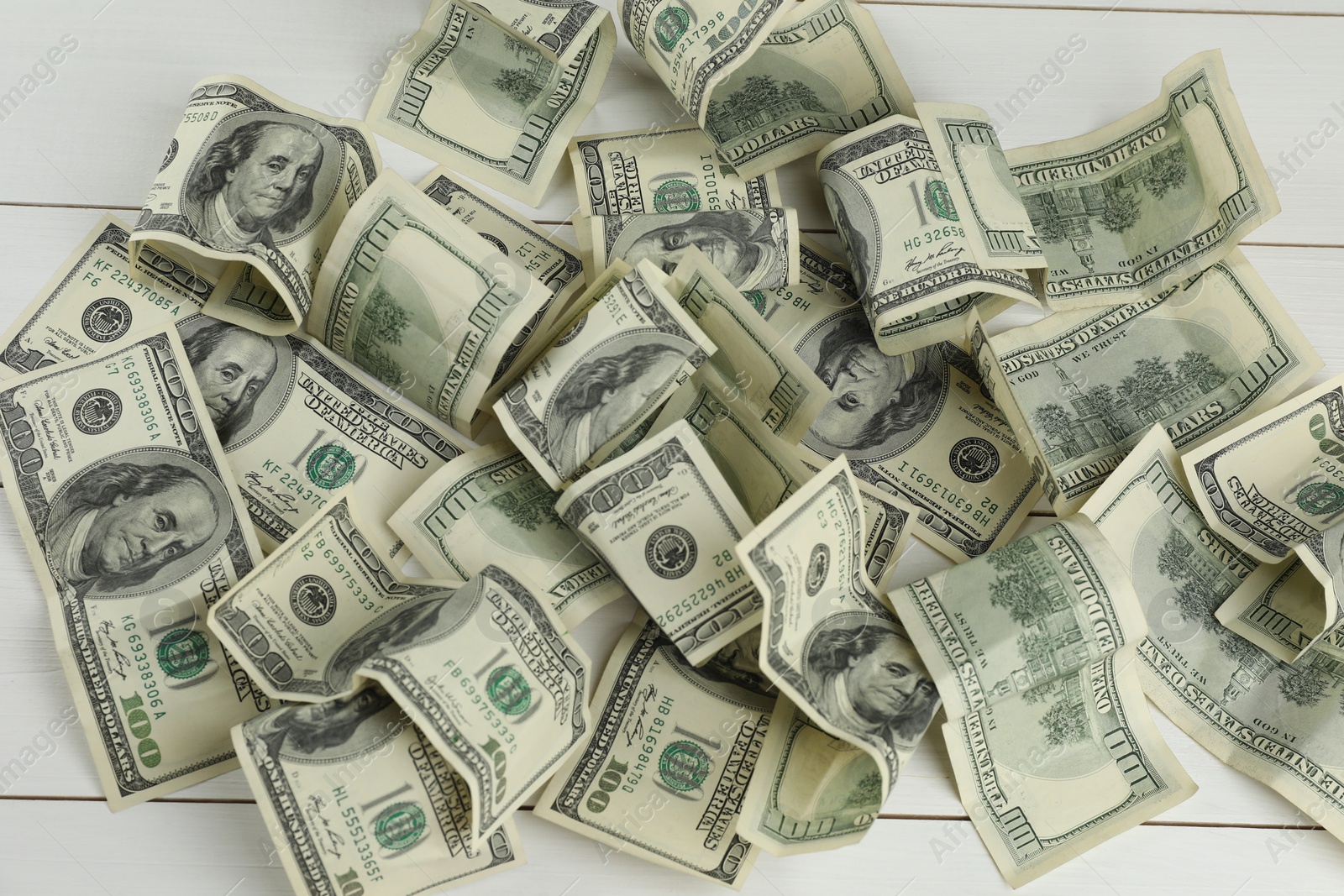 Photo of Money exchange. Dollar banknotes on white wooden background, top view