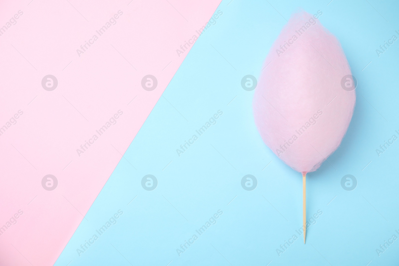 Photo of Sweet pink cotton candy on color background, top view. Space for text