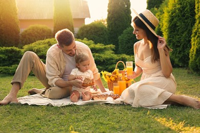 Happy family having picnic in garden on sunny day