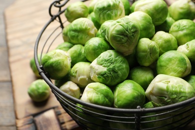 Metal basket with fresh Brussels sprouts on table, closeup