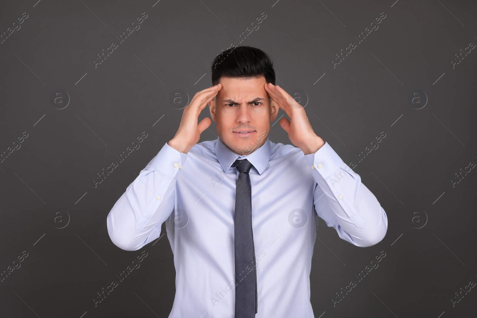 Photo of Portrait of emotional businessman on dark grey background. Personality concept