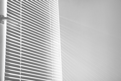 Photo of Window with closed horizontal blinds indoors. Space for text