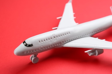 Photo of Toy airplane on red background, closeup view