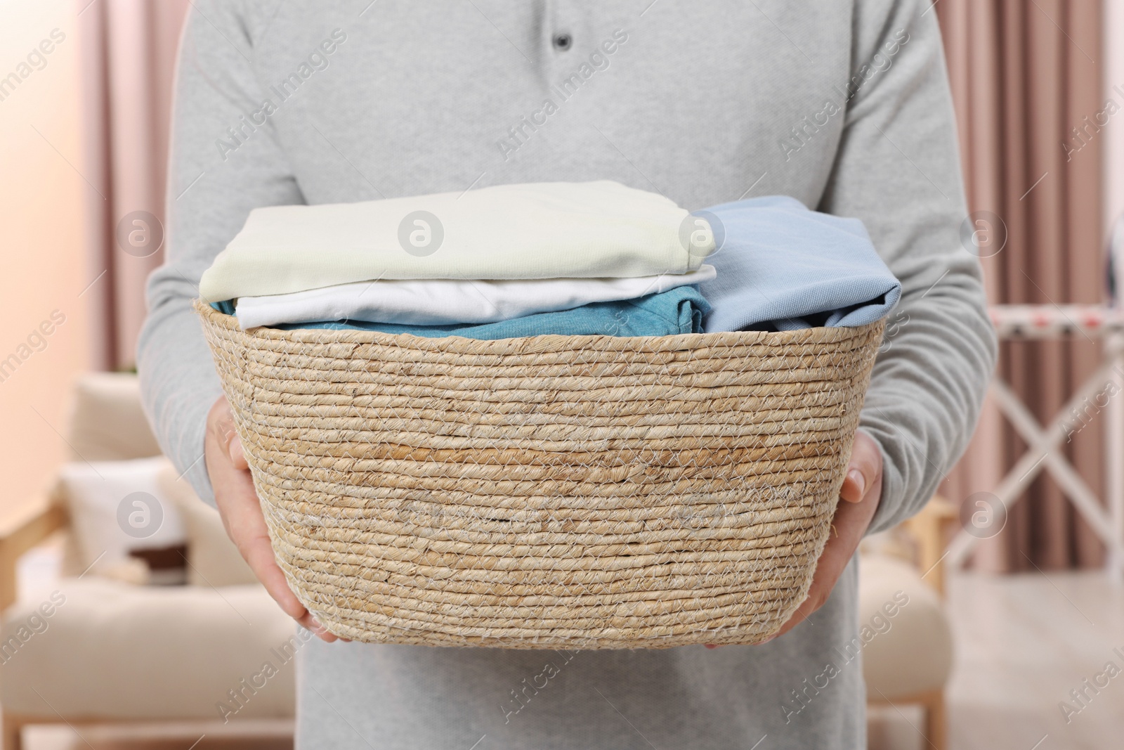 Photo of Man with basket full of laundry at home, closeup