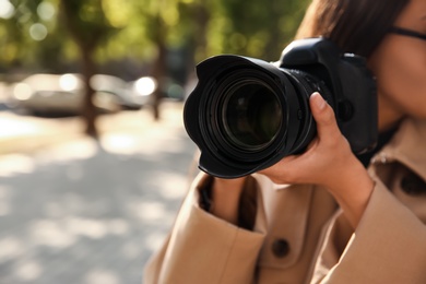 Photo of Private detective with camera spying outdoors, closeup