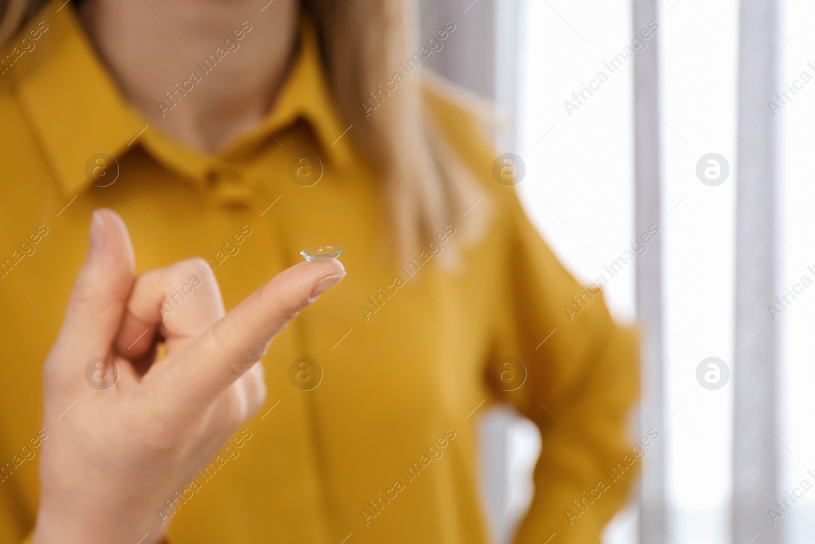 Photo of Woman holding contact lens, closeup