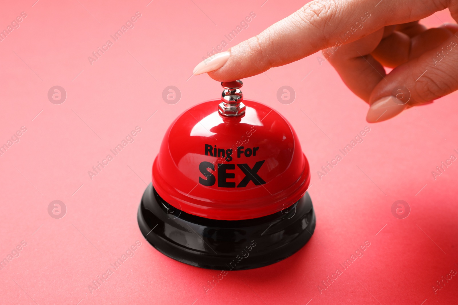 Photo of Young woman with sex bell on red background, closeup