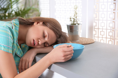 Photo of Young woman sleeping at table in morning